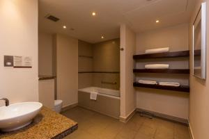 a bathroom with a sink and a toilet and a tub at Staybridge Suites Yas Island Abu Dhabi, an IHG Hotel in Abu Dhabi