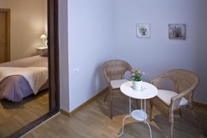 バルセロナにあるFlateli Pelaiのテーブル、椅子2脚、ベッド1台が備わる客室です。