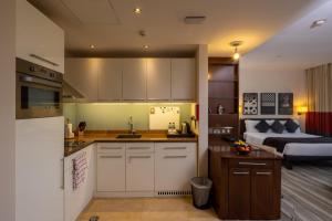 a kitchen with white cabinets and a bed in a room at Staybridge Suites Yas Island Abu Dhabi, an IHG Hotel in Abu Dhabi