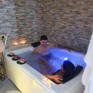 Un uomo e una donna in una vasca da bagno di Mary Gery's Rooms a Castellammare del Golfo