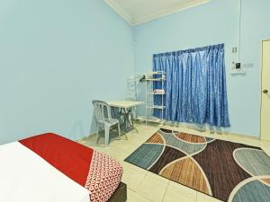 Cette chambre comprend un lit, une table et une fenêtre. dans l'établissement OYO 90551 Zn Mix Homestay & Roomstay, à Kampung Raja