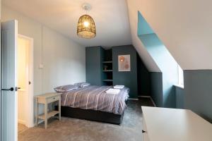 um quarto com uma cama e uma parede azul em The Penthouse em Cromer