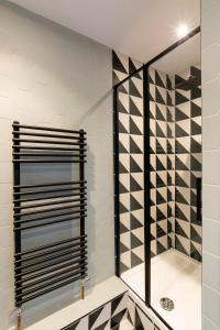 a walk in shower with black and white tile at The Penthouse in Cromer +39 photos