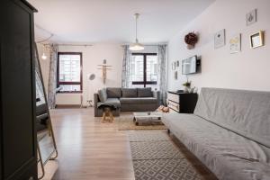 a living room with a couch and a cross on the wall at King Care Apartment with A/C in Budapest
