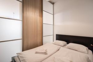 a bedroom with a bed with white sheets and a window at King Care Apartment with A/C in Budapest
