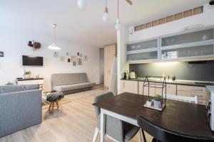 eine Küche und ein Wohnzimmer mit einem Tisch und einem Sofa in der Unterkunft King Care Apartment with A/C in Budapest