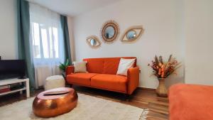 a living room with an orange couch and a mirror at Warm Family Snug in Budapest