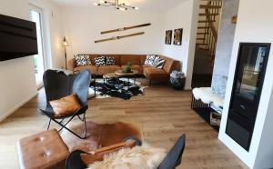 sala de estar con sofá y sillas en Design-Ferienhaus "auf der Schanz" mit privater Sauna - Todtnau-Muggenbrunn, Feldberg im Schwarzwald en Muggenbrunn