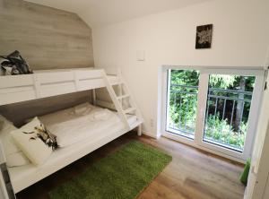 Etagenbett in einem Zimmer mit Fenster in der Unterkunft Design-Ferienhaus "auf der Schanz" mit privater Sauna - Todtnau-Muggenbrunn, Feldberg im Schwarzwald in Muggenbrunn