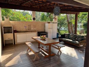 a kitchen and living room with a wooden table at Marina Guest House in Búzios