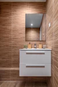 La salle de bains est pourvue d'un lavabo blanc et de murs en bois. dans l'établissement Cosy flat in Saint-Germain des près, à Paris