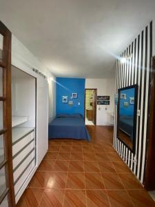1 dormitorio con 1 cama azul y suelo de madera en Casa em Arraial do Cabo, en Arraial do Cabo