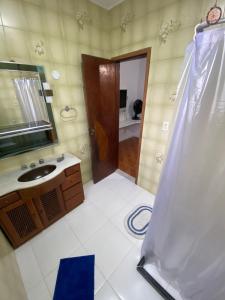 y baño con ducha, lavabo y espejo. en Casa em Arraial do Cabo, en Arraial do Cabo