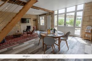 een eetkamer en een woonkamer met een tafel en stoelen bij L'Epicure in Langoiran