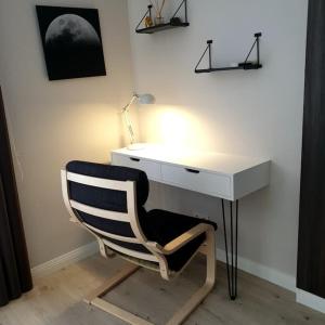 a desk with a chair under a desk with a lamp at Lovely 1-bedroom rental unit in downtown in Dushanbe