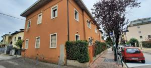 un edificio arancione con un'auto rossa parcheggiata accanto di SUITE BETTy a Mestre