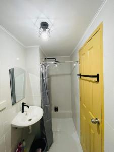 a bathroom with a sink and a yellow door at Lovely 2 bedroom condo unit in Iloilo City