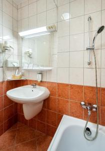 a bathroom with a sink and a bath tub at Hunguest Hotel Freya in Zalakaros