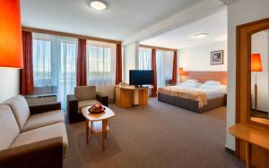 Habitación de hotel con cama y sofá en Hunguest Hotel Freya en Zalakaros