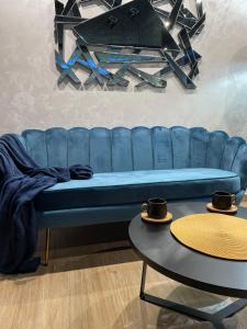 a blue couch in a room with two tables at Apartman Stefan Lux in Vrdnik
