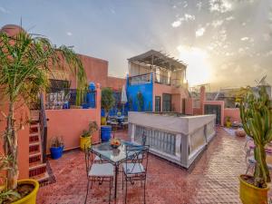 a patio with a table and chairs and plants at Riad Sun of Kech in Marrakesh