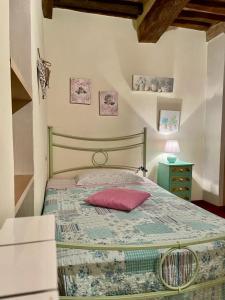 Un dormitorio con una cama con una almohada roja. en La casina del Poggio, en Buonconvento