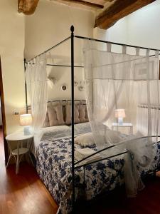1 dormitorio con cama con dosel y mesa en La casina del Poggio, en Buonconvento