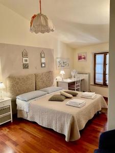 1 dormitorio con 1 cama grande, mesa y silla en La casina del Poggio, en Buonconvento