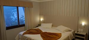 um quarto com uma cama com um cobertor em cima em Pousada do Verde Gramado em Gramado