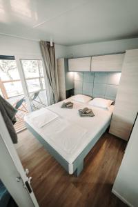een groot wit bed in een kamer met een raam bij SEA HOUSE pine shade, pool & jacuzzi - PRIVILEGE POINT camping villas in Selce