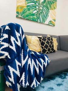a blue and white blanket on a couch with pillows at Lovely 2 bedroom condo unit in Iloilo City