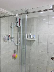 a bathroom with a shower with a glass door at Studio type with Free Parking in Kababae