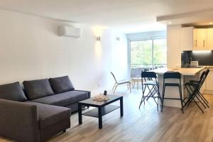 salon z kanapą i stołem w obiekcie Résidence Anthérieu - Appartements neufs tout confort w mieście Frontignan