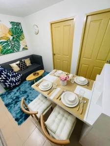 a dining room with a table and chairs and a couch at Lovely 2 bedroom condo unit in Iloilo City