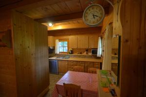 une cuisine avec une table et une horloge au plafond dans l'établissement Meadow Ranch Holiday Home, à Jaroslavické Paseky