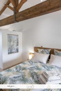 ein Schlafzimmer mit einem großen Bett und einer Holzdecke in der Unterkunft L'Epicure in Langoiran