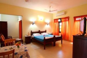 1 dormitorio con 1 cama, mesa y sillas en Alps Residency, en Madurai
