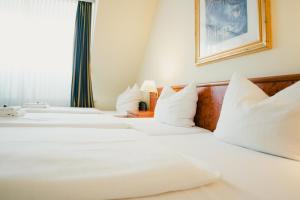 2 bedden in een hotelkamer met witte kussens bij Altstadt Hotel St. Georg in Düsseldorf