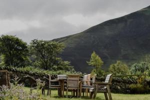 a wooden table and chairs in front of a mountain at The Dash Farmhouse in Bassenthwaite