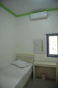 a small room with a bed and a window at Penginapan AIRA in Palu