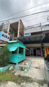 a building with a blue shack in front of it at Penginapan AIRA in Palu