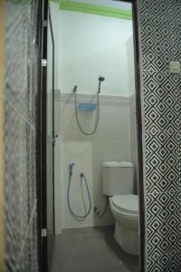 a bathroom with a shower with a toilet and a shower at Penginapan AIRA in Palu