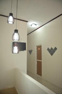 a bathroom with two lights and a mirror at Penginapan AIRA in Palu