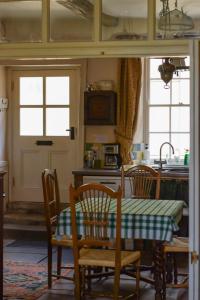 a kitchen with a table and chairs and a kitchen withwindows at The Dash Farmhouse in Bassenthwaite