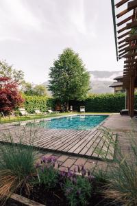 a swimming pool with a wooden deck in a yard at Gasthof Residence Brugghof & Erlhof in Campo Tures
