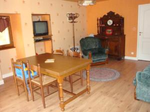 - un salon avec une table, des chaises et une télévision dans l'établissement Fermette Rénovée, à Celles