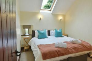 a bedroom with a large bed with blue pillows at Elliott Cottage in Buxton