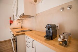 een kleine keuken met een spoelbak en een magnetron bij 188 Apartments - Buganvília - pool and balcony in Cascais