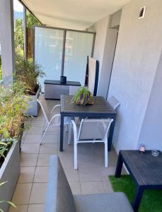 eine Terrasse mit einem Tisch und Stühlen auf dem Balkon in der Unterkunft Appart Cosy proche du lac avec terrasse in Annecy