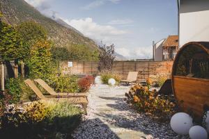 un jardín con 2 bancos y una pared de retención en Residence Montani, en Laces